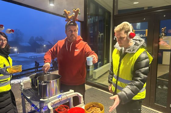 en gruppe mennesker som står rundt et bord med mat på