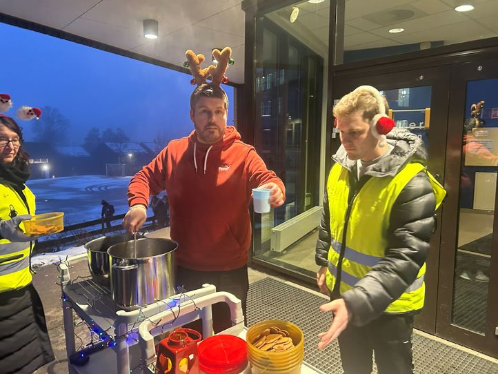 en gruppe mennesker som står rundt et bord med mat på