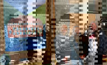 en gruppe mennesker som poserer for et bilde foran et maleri
