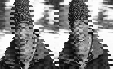 en person med hatt og smilende til kameraet