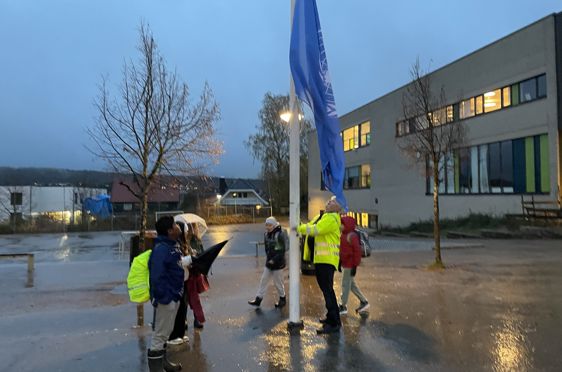 en gruppe mennesker som går i regnet med paraplyer